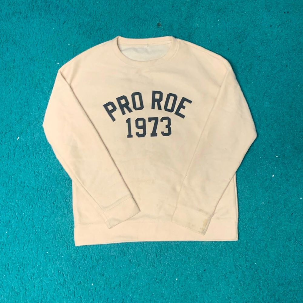 Cream sweatshirt with PRO ROE 1973 written on front.